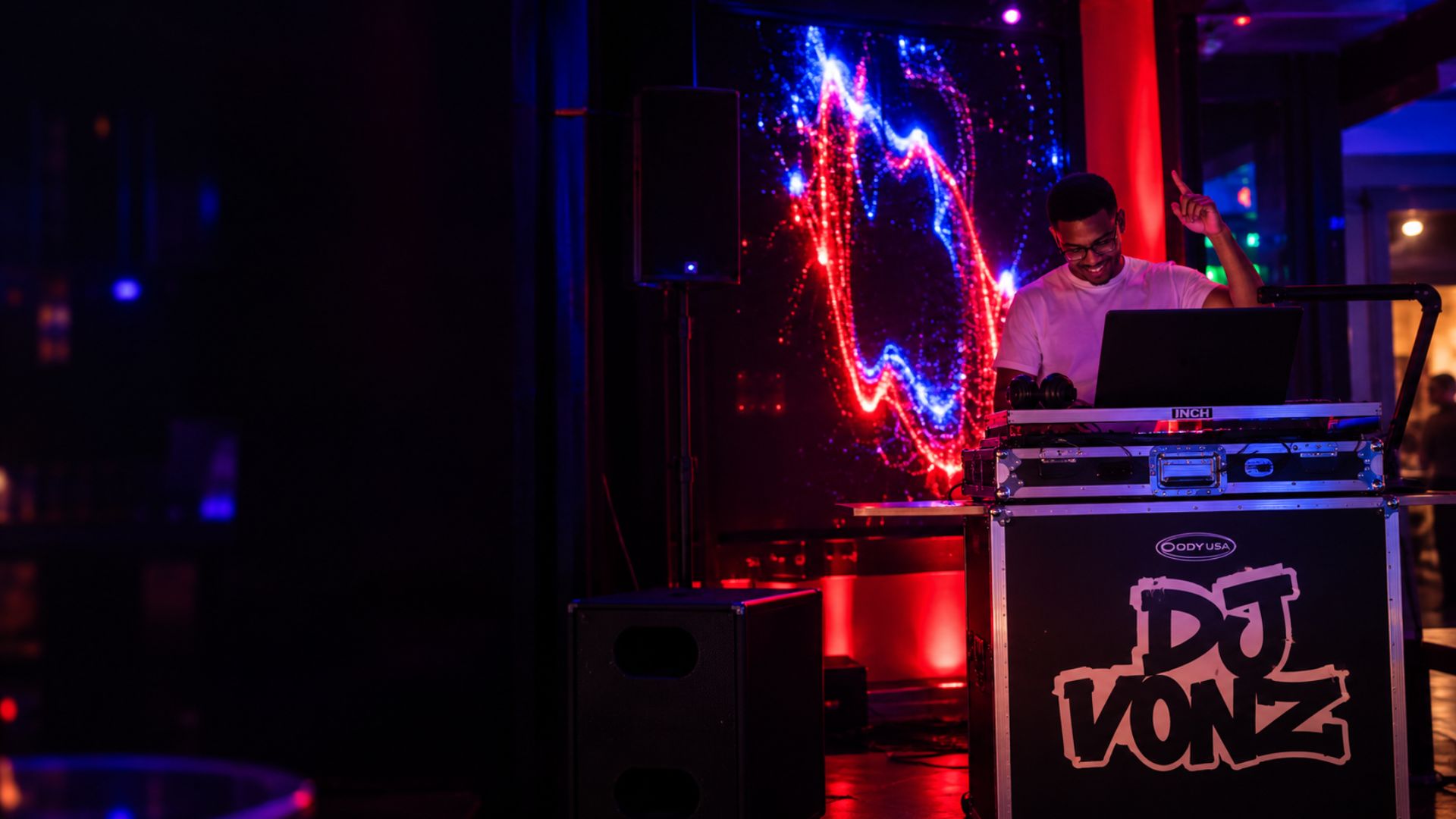 DJ Vonz performing behind his booth at Pisco After Dark in Uptown Charlotte